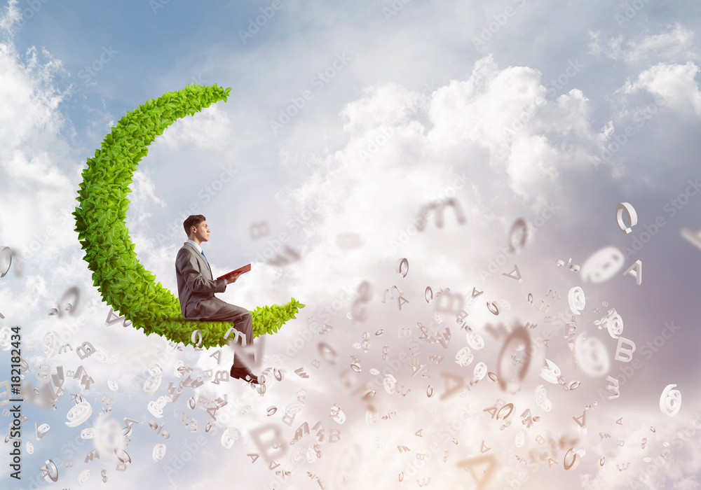 Man or student sitting on green moon and reading book Man or student sitting on green moon and reading book