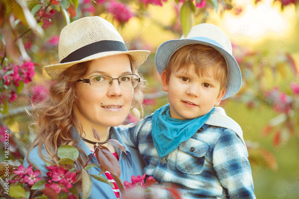 Obraz premium Mom and son have fun in the park. Tenderness, hugs and joy outside the room. Mothers Day.