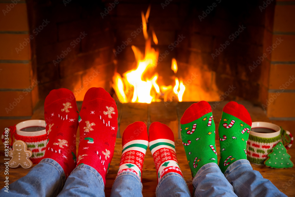 Family in Christmas socks near fireplace Stock Photo | Adobe Stock