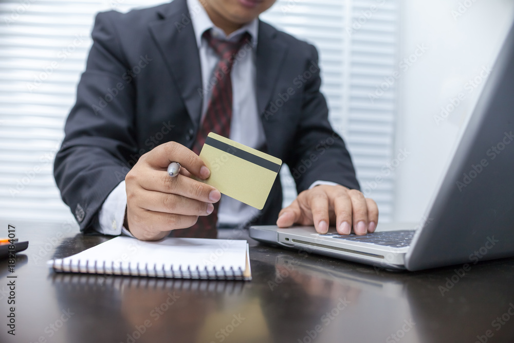 businessman holding credit card and using laptop computer. Online shopping concept businessman holding credit card and using laptop computer. Online shopping concept