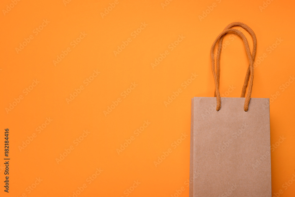 Craft cardboard gift bag on orange background Craft cardboard gift bag on orange background