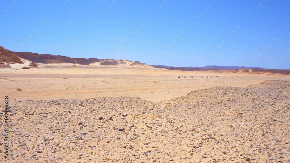 Skyline Aerial view of young men riding quad bikes over sand dunes in desert. The race in difficult conditions on the sand on a quad bike Skyline Aerial view of young men riding quad bikes over sand dunes in desert. The race in difficult conditions on the sand on a quad bike