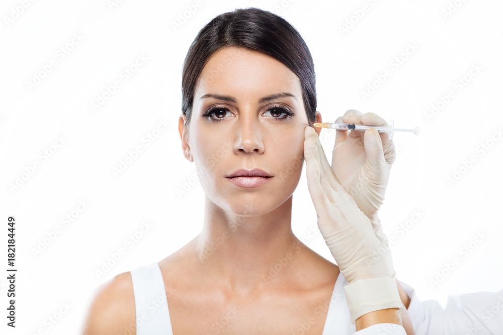 Beautiful young woman getting botox cosmetic injection in her face. Beautiful young woman getting botox cosmetic injection in her face.
