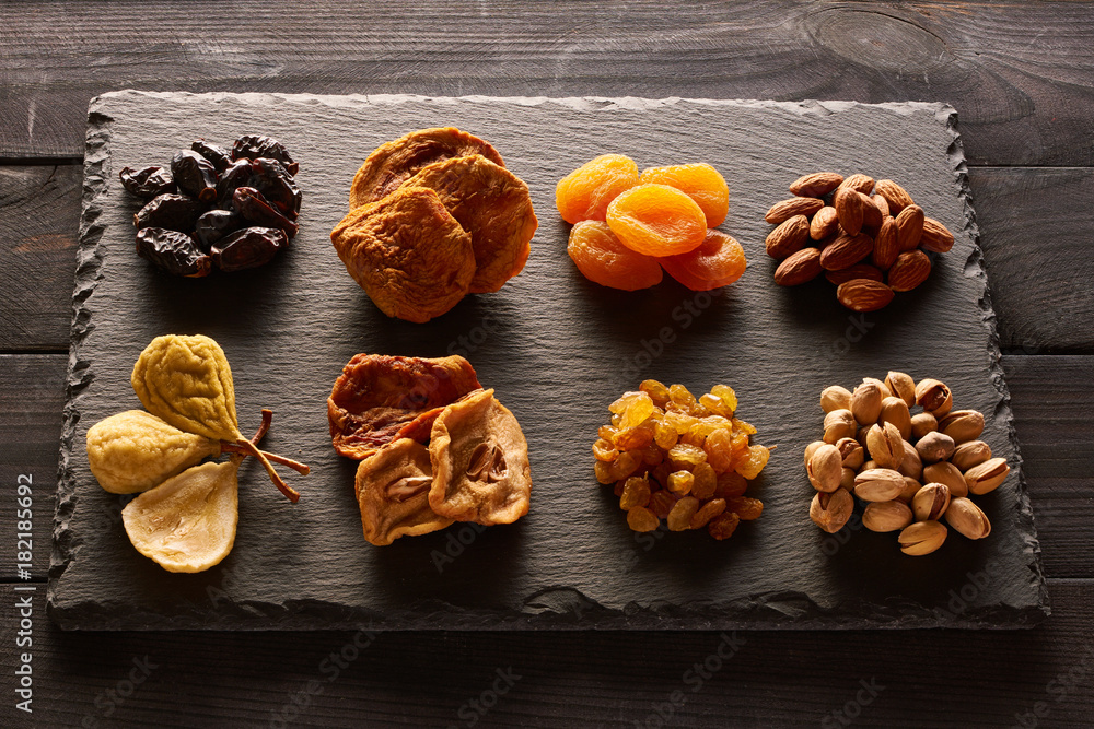 Fototapeta premium Dried fruits and nuts on slate plate