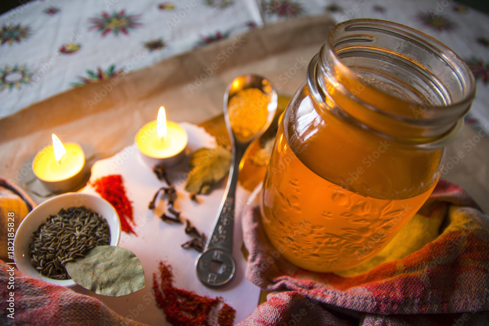 Ghee or clarified butter in a glass jar with Indian spices on the table Ghee or clarified butter in a glass jar with Indian spices on the table