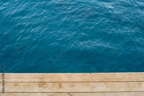 Top view deep blue sea and wooden floor of a pier. © allasimacheva