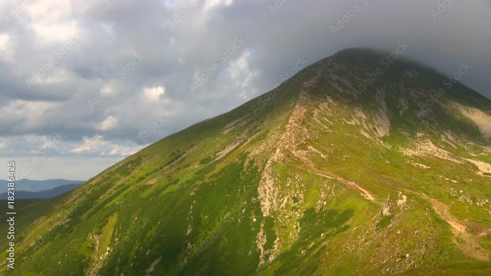 Highest mountain peak in the low rays of the sun covered clouds. Time lapse. Highest mountain peak in the low rays of the sun covered clouds. Time lapse.