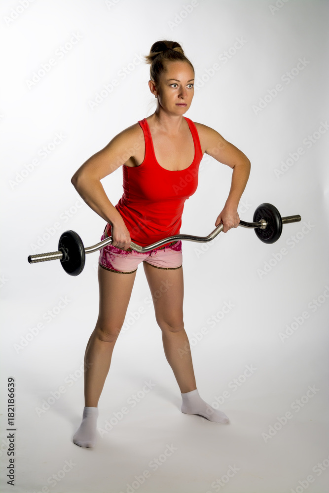 Obraz premium Girl with a barbell on a white background.