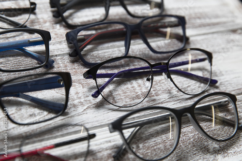 A lot of eyeglasses on a light wooden background