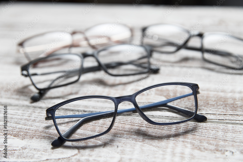 Four pairs of eyeglasses on a light wooden background Four pairs of eyeglasses on a light wooden background