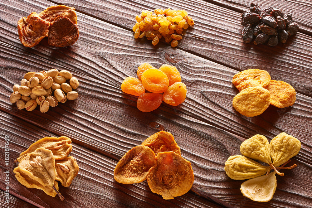 Fototapeta premium Dried fruits and nuts on wooden background
