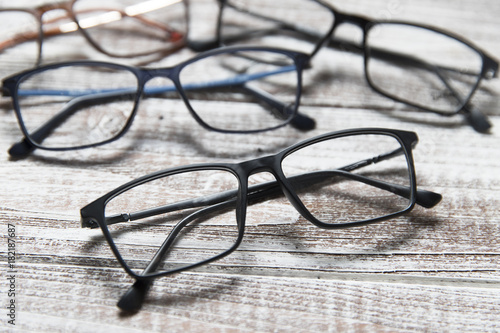 Four pairs of eyeglasses on a light wooden background