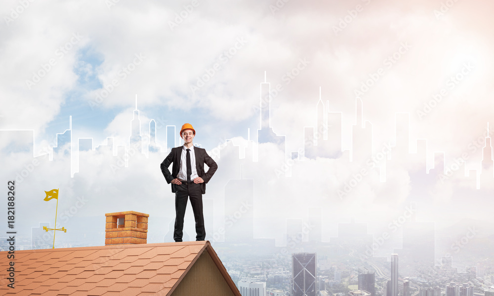 Engineer man standing on roof and looking away. Mixed media Engineer man standing on roof and looking away. Mixed media