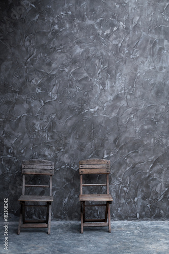 Old vintage chair wooden at dark concrete wall texture