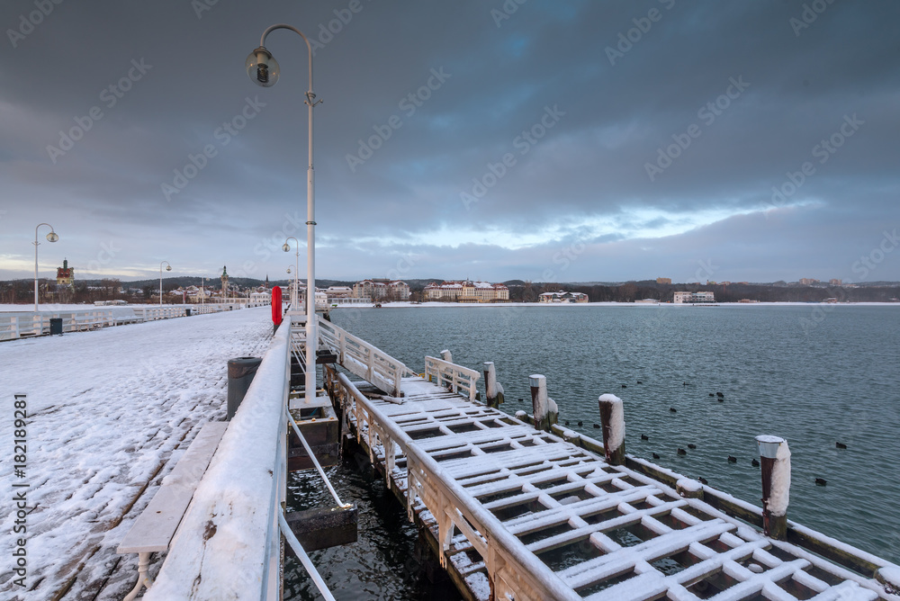 Early morning at snow covered pier in Sopot. Winter landscape. Poland.