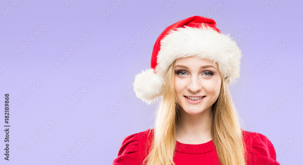 Beautiful, young and pretty girl in Christmas hat over background with snow. Beautiful, young and pretty girl in Christmas hat over background with snow.