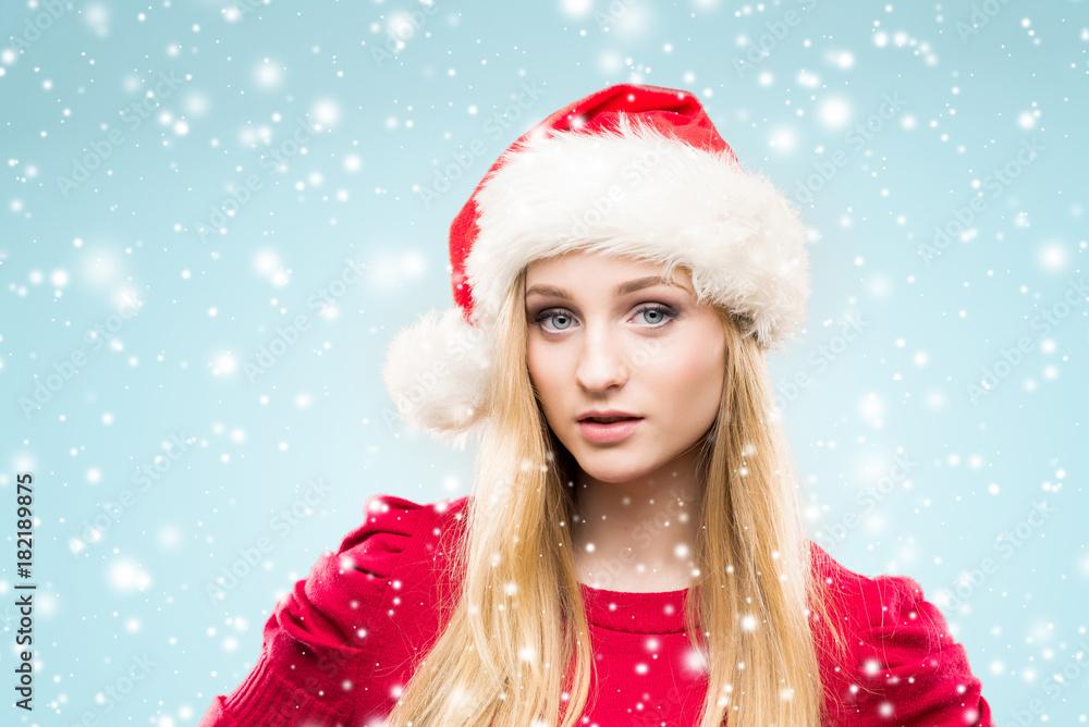 Beautiful, young and pretty girl in Christmas hat over background with snow. Beautiful, young and pretty girl in Christmas hat over background with snow.