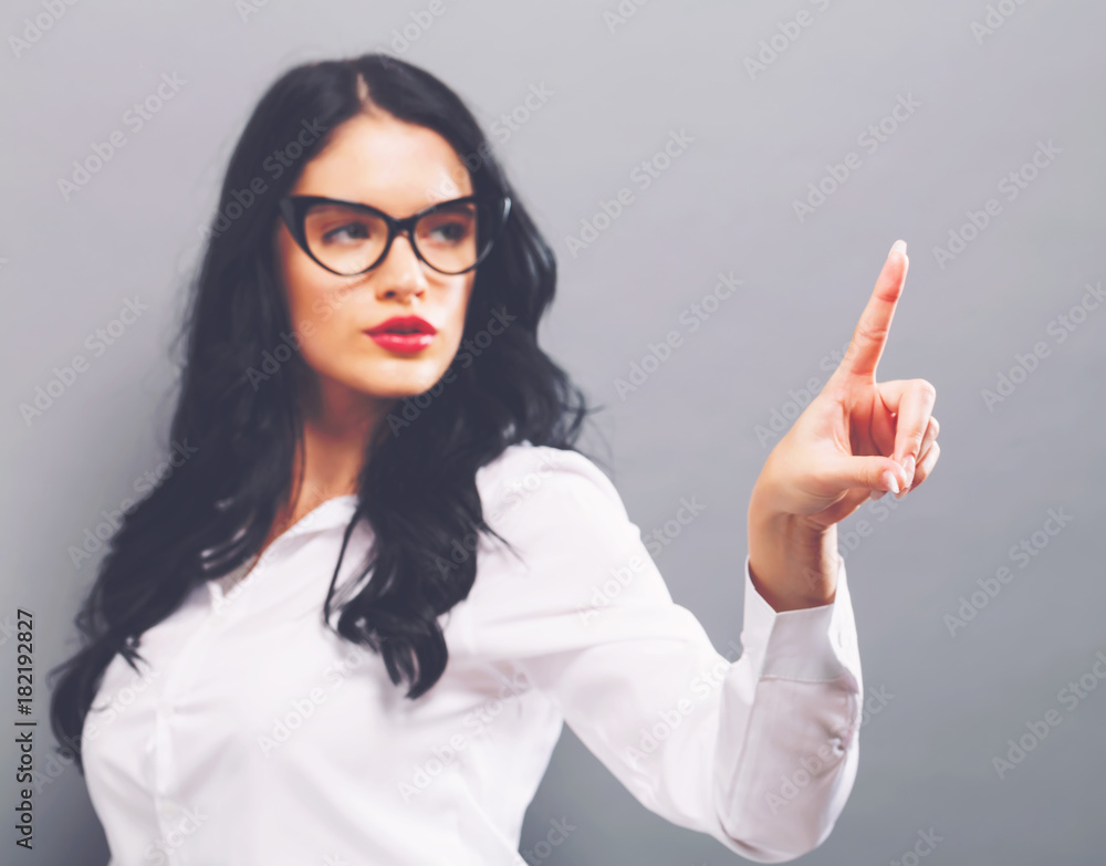 Young woman pointing at something on a solid background Young woman pointing at something on a solid background