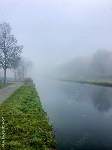 A foggy morning over a river in a typically Belgian countryside landscape
