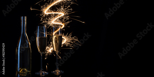 Glasses and bottle of champagne in the festive sparks of Bengal 