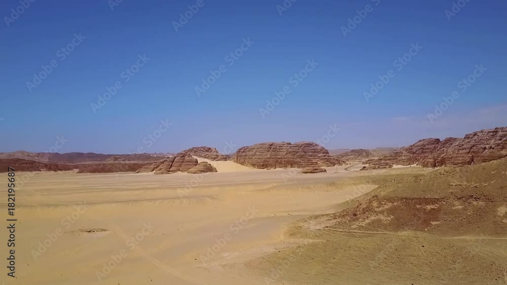 Aerial view of the sand dunes and mountain. Desert at sunset - mountain landscape with dust. Aerial view of the sand dunes and mountain. Desert at sunset - mountain landscape with dust.