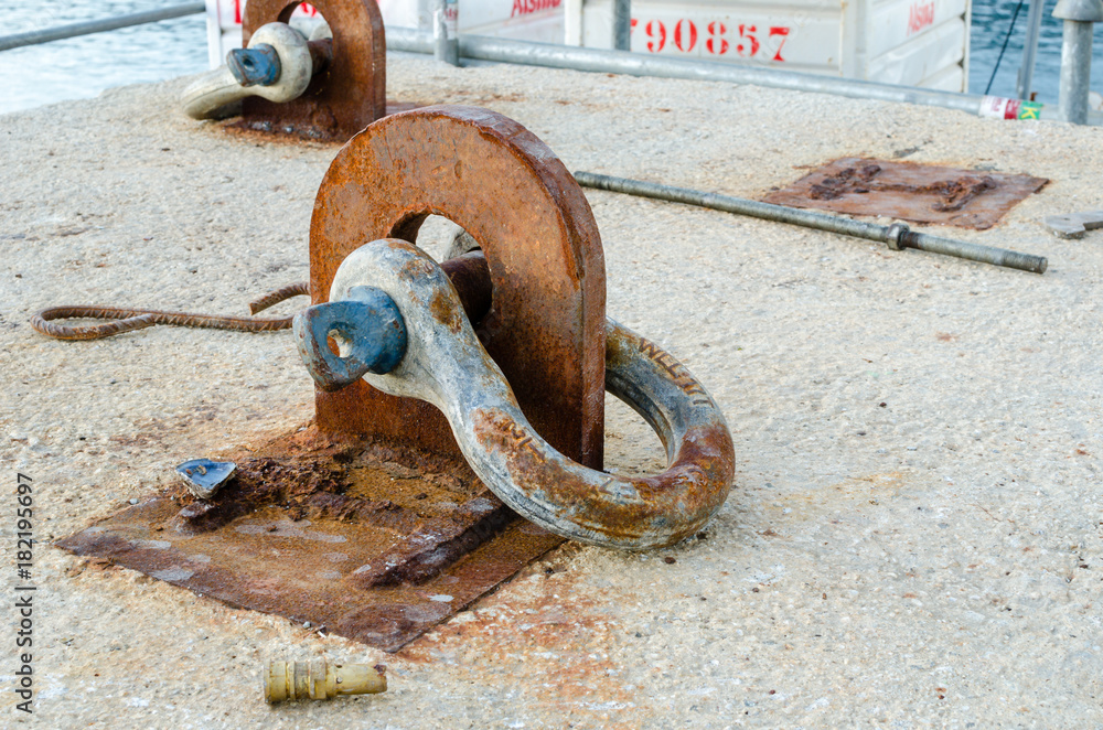 Old rusted shackle anchoring device on a concrete surface Stock Photo