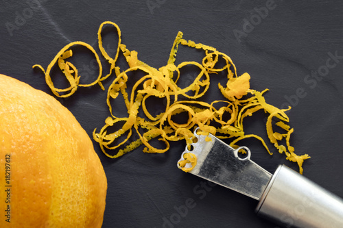 Orange Zest and Zester Top View on Dark Slate photo