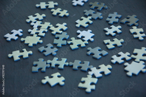 A lot of white and gray puzzles on a black background.