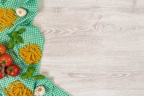 Italian pasta raw ingredients on wooden background.