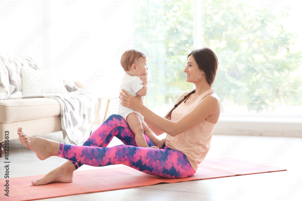Young mother doing yoga with baby at home Young mother doing yoga with baby at home