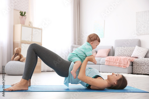 Young mother doing yoga wit...
