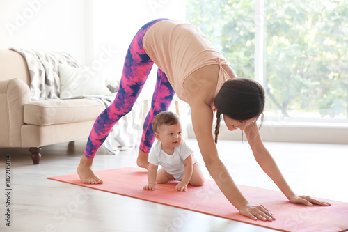 Young mother doing yoga wit...