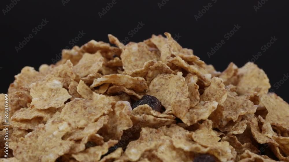 Granola cereal, nuts and raisins rotating . Crunchy tasty muesli food background close-up. Cereals and dried food mixed for breakfast Granola cereal, nuts and raisins rotating . Crunchy tasty muesli food background close-up. Cereals and dried food mixed for breakfast