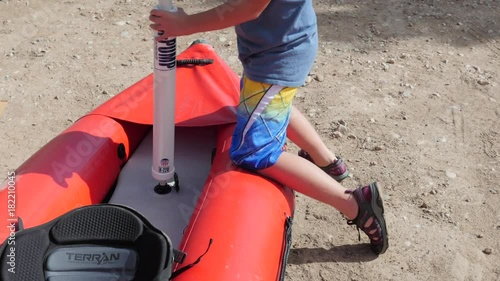 A boy pumping a river kayak to run the colorado river photo