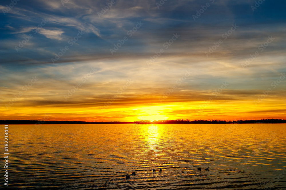 Sunset Over a lake in Oklahoma with ducks swimming .