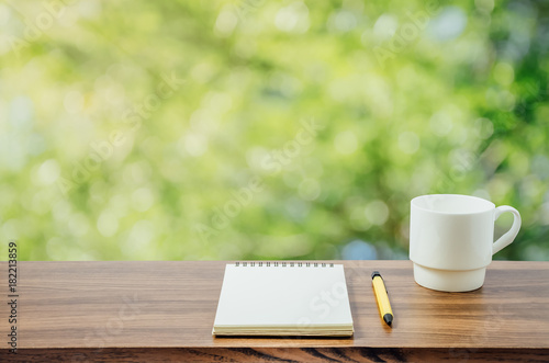 Hot coffee, , notebook and pen in nature background