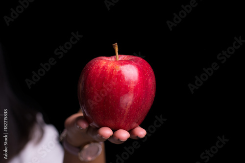 Woman holding red apple on isolate black background