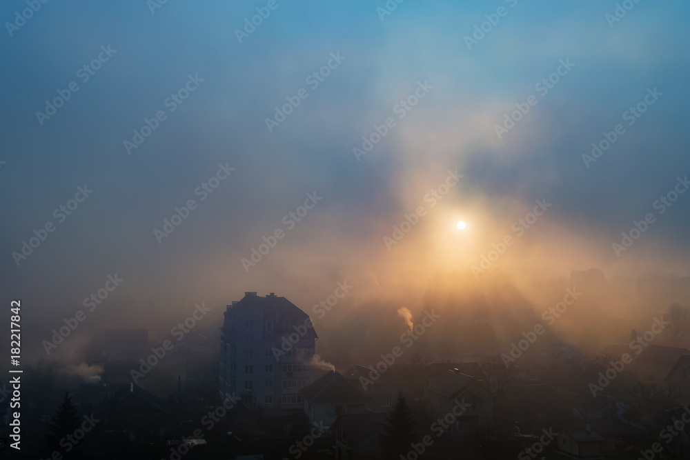 rays of the sun make their way through the morning mist over the city of Ivano-Frankivsk, Ukraine