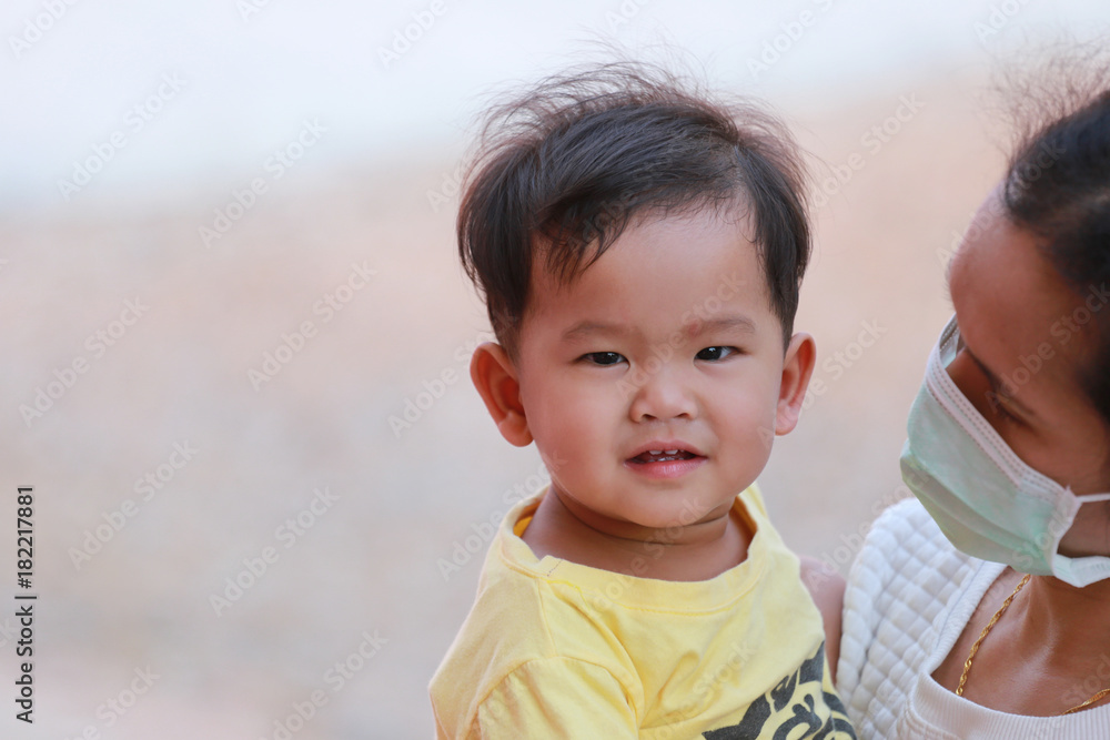 Asian boy in yellow dress in embrace your mother is carrying. Asian boy in yellow dress in embrace your mother is carrying.