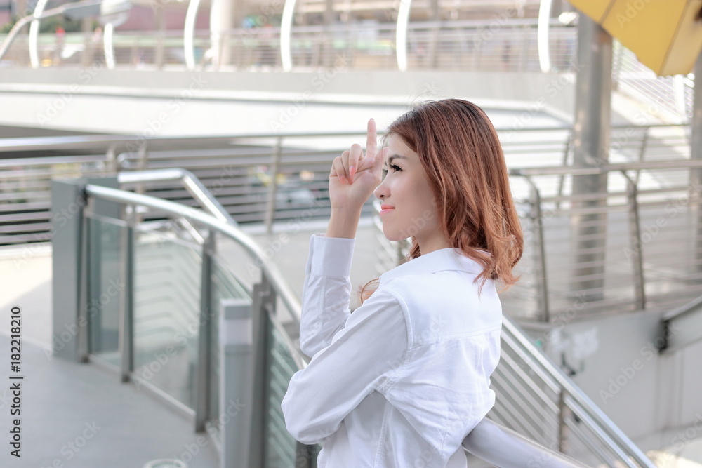 Candid shot of attractive young Asian secretary woman standing and smile at city with copy space background.Candid shot of attractive young Asian secretary woman standing and smile at city background. Candid shot of attractive young Asian secretary woman standing and smile at city with copy space background.Candid shot of attractive young Asian secretary woman standing and smile at city background.