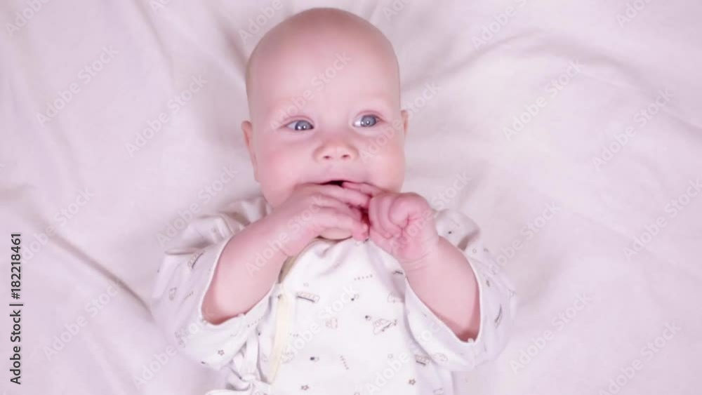 Slow motion portrait of adorable blue-eyed 6 months old baby boy smiling . Slow motion portrait of adorable blue-eyed 6 months old baby boy smiling .