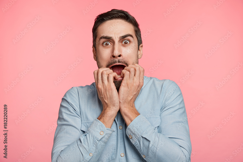 Portrait of anxious scared bearded male looks nervously at camera, worries about girlfriend`s health, who is in difficult situation after car accident. Panic young man recieves shocking news Portrait of anxious scared bearded male looks nervously at camera, worries about girlfriend`s health, who is in difficult situation after car accident. Panic young man recieves shocking news