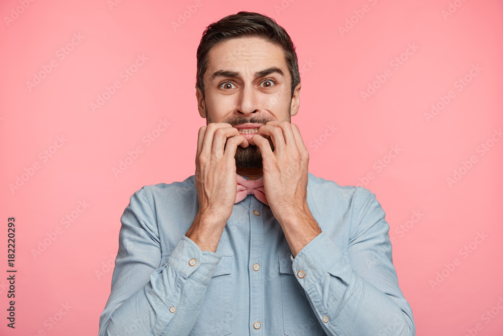 Stressful miserable nervous male bites fingers, clenches teeth, has sorrorful and worried expression, feels frustrated after failing entrance exam, not accepted to students community. Tragic news Stressful miserable nervous male bites fingers, clenches teeth, has sorrorful and worried expression, feels frustrated after failing entrance exam, not accepted to students community. Tragic news