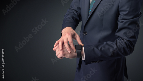 Man in suit wearing smartwatch. © ra2 studio