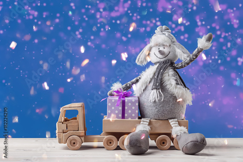 Happy snowman with Christmas gifts in toy truck.