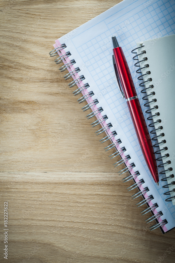 Spiral copybooks pen on wooden board Spiral copybooks pen on wooden board