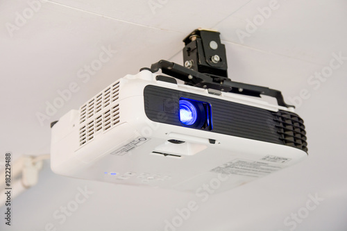 Canvas Print White projector hanging on the ceiling of conference room.