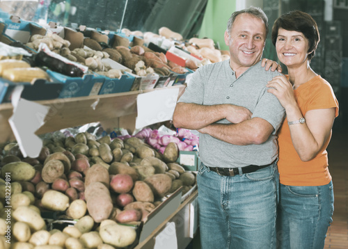 Portrait of positive mature couple in the fruit shop