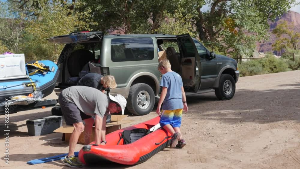 A family pumping a river kayak to run the colorado river A family pumping a river kayak to run the colorado river