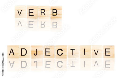 Black verb and adjective word with reflection, on wooden blocks on white isolated background.